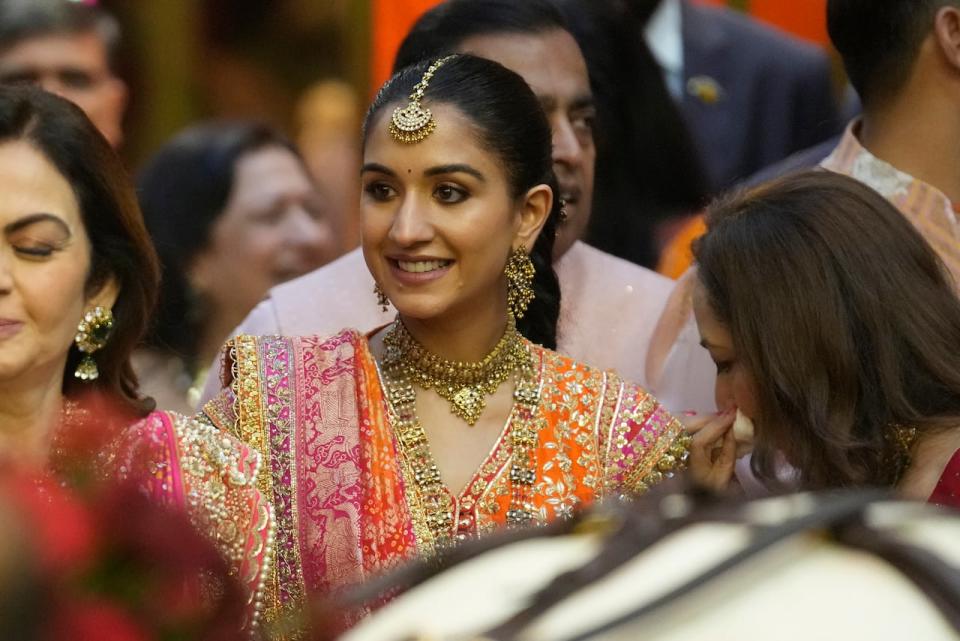 Radhika Merchant, fiancée of Anant Ambani, centre, smiles during her pre-wedding ceremony at Antilia in Mumbai last week. 