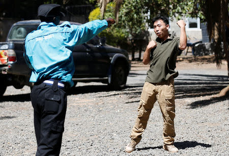 Chinese national Jack Wang, a security trainer at the Chinese-run Deway Security Group leads Kenyan security guards in martial arts combat training at their company compound in Kenya's capital Nairobi, March 13, 2017. REUTERS/Thomas Mukoya