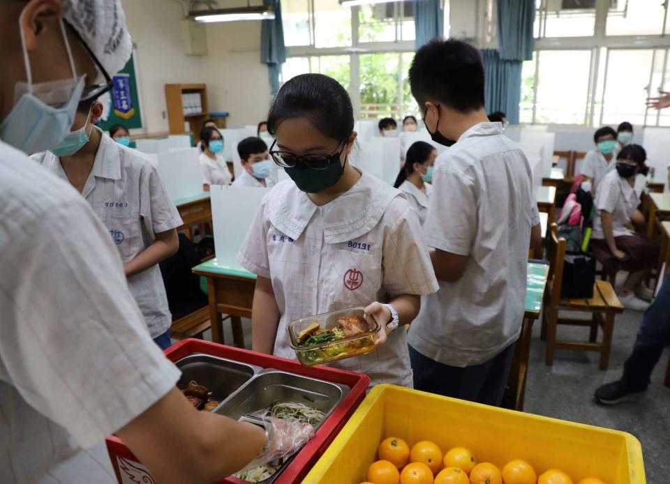 學生用餐時不併桌共食、不交談，維持社交距離或使用隔板。   圖：新北市教育局／提供