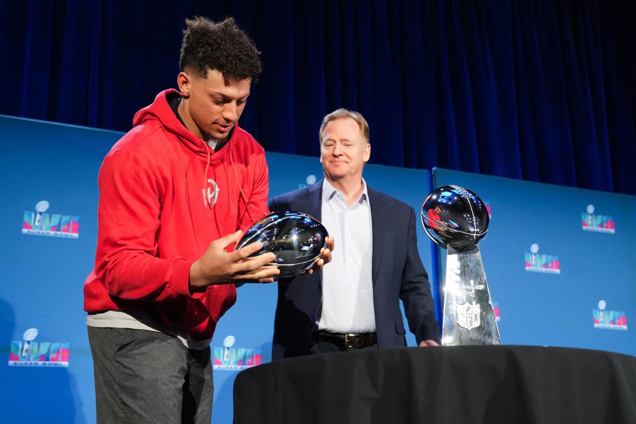 Chiefs QB Patrick Mahomes picks up the Super Bowl MVP trophy alongside NFL commissioner Roger Goodell during a news conference for the winning coach and MVP of Super Bowl 57.