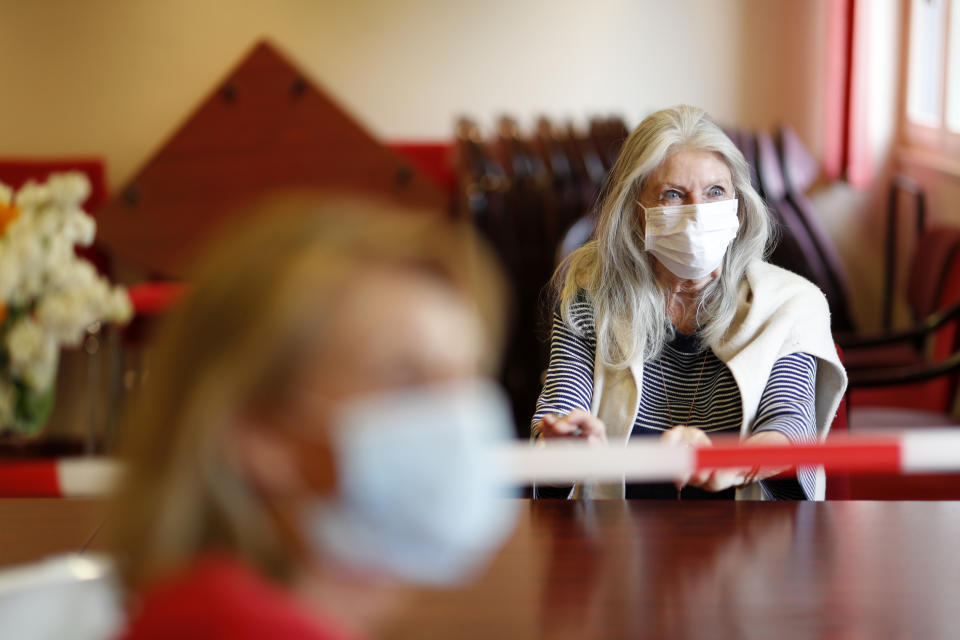 In this April 21, 2020, photo, Josiane Cohen, right, meets her daughter Laetitia at the Kaysersberg nursing home, eastern France. France has started to break the seals on its locked down nursing homes, allowing limited visitation rights for the families of elderly residents. The visits are proving bittersweet for some, too short and restricted to make up for weeks of isolation and loneliness. But they are shedding light on the immense emotional toll caused by locking down care homes. (AP Photo/Jean-Francois Badias)