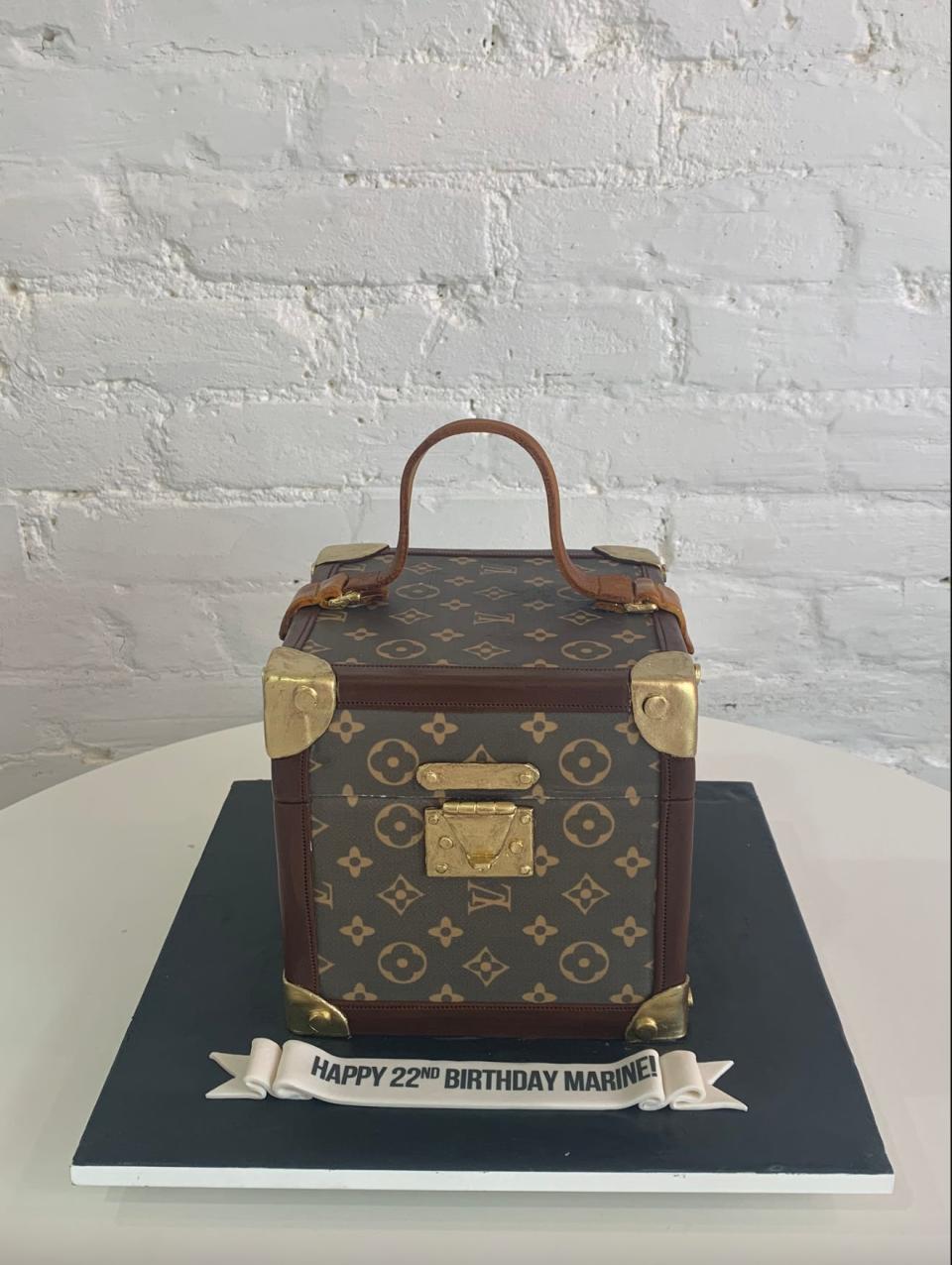 A cake replica of a Louis Vuitton handbag with the words, "Happy 22nd birthday Marine!" at the base.