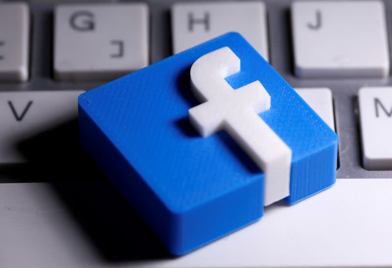 A 3D-printed Facebook logo is seen placed on a keyboard in this illustration