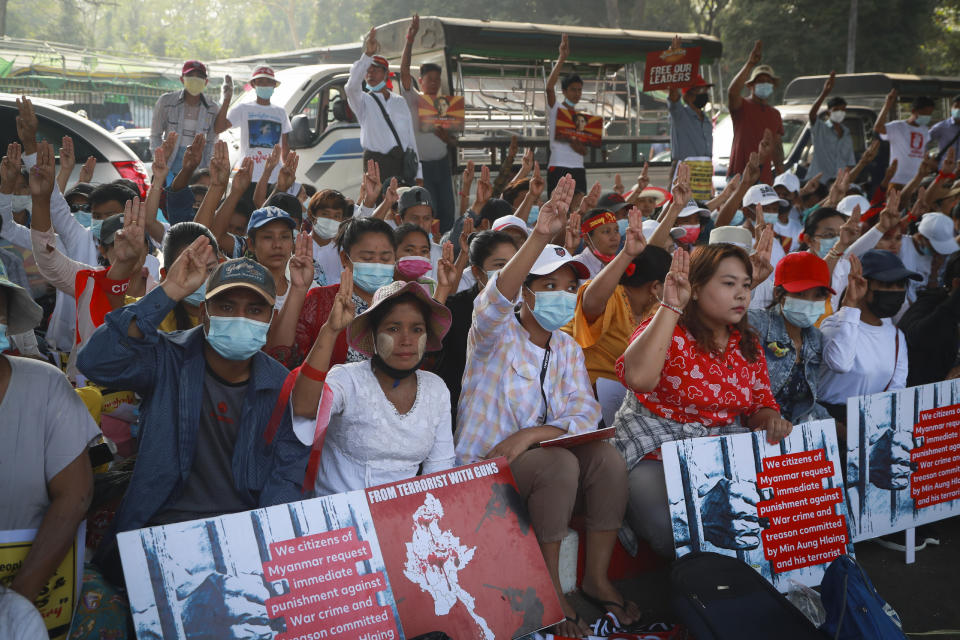 Protesters flash the three-fingered salute of resistance as they take part in a demonstration against the military coup in Yangon, Myanmar, Friday, Feb. 26, 2021. Tensions escalated Thursday on the streets of Yangon, Myanmar's biggest city, as supporters of Myanmar's junta attacked people protesting the military government that took power in a coup, using slingshots, iron rods and knives to injure several of the demonstrators. (AP Photo)