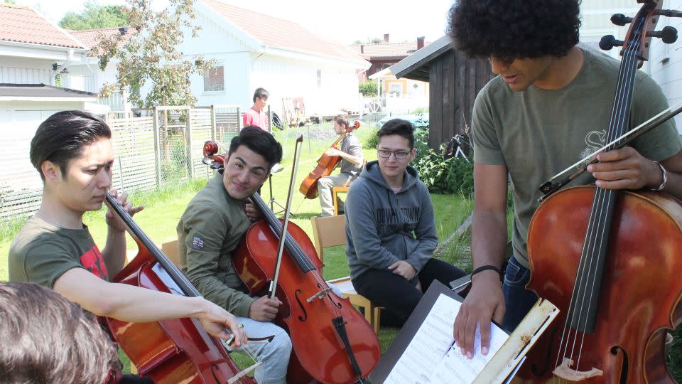 Mostafa Kazemi, center, smiles during a cello section rehearsal. He'd never played an instrument before joining the Dream Orchestra. - Courtesy Dream Orchestra