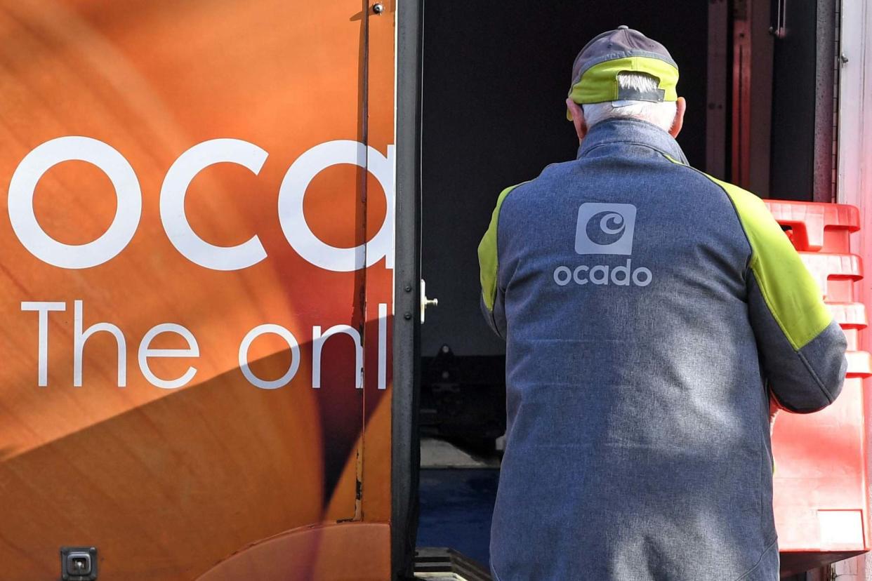 A delivery driver returns empty crates to his Ocado delivery van: AFP via Getty Images