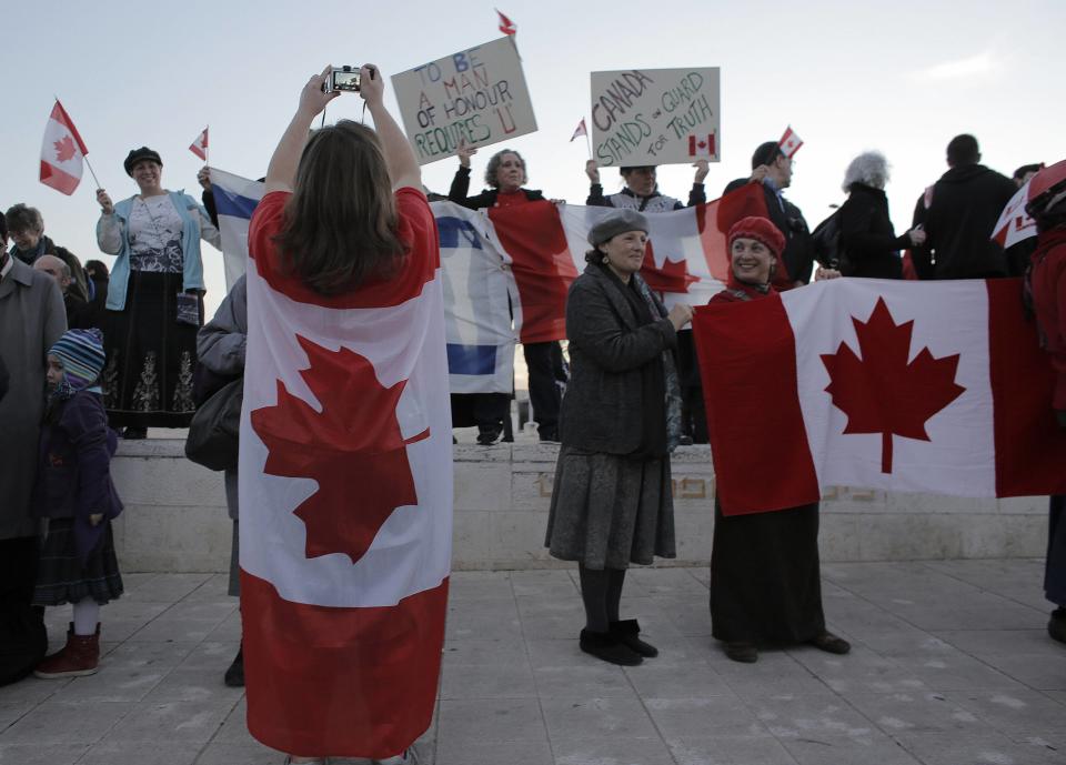 Israelis hold signs and Canadian flags at a rally to thank Canada's Prime Minister Stephen Harper for his support of Israel during his visit at the Israeli parliament in Jerusalem January 20, 2014. REUTERS/Ammar Awad (JERUSALEM - Tags: POLITICS)