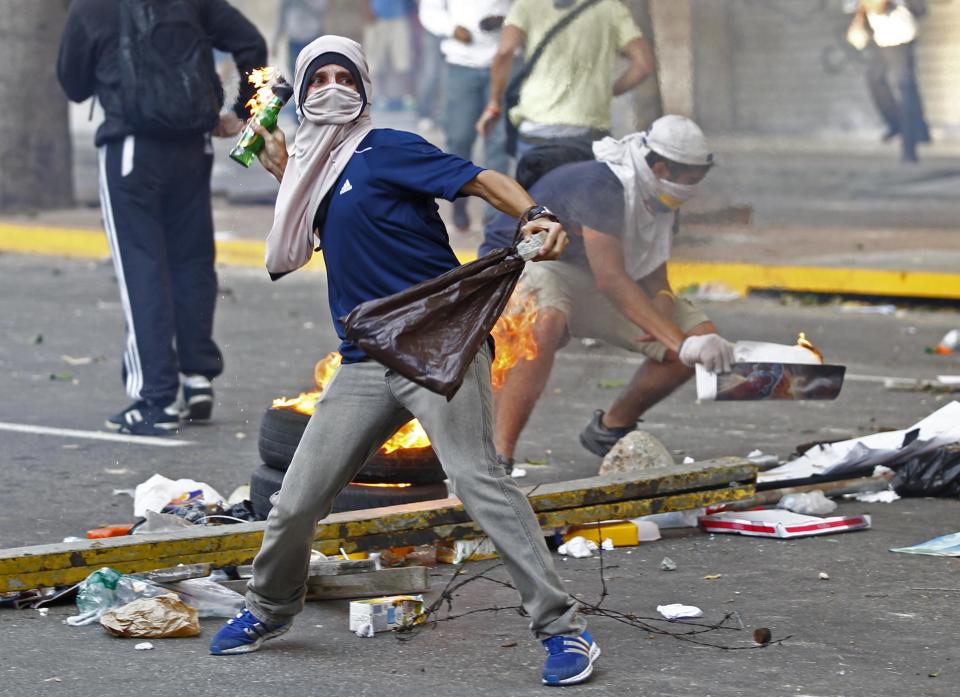 Demonstrators confront police as they protest against the government of President Nicolas Maduro in Caracas