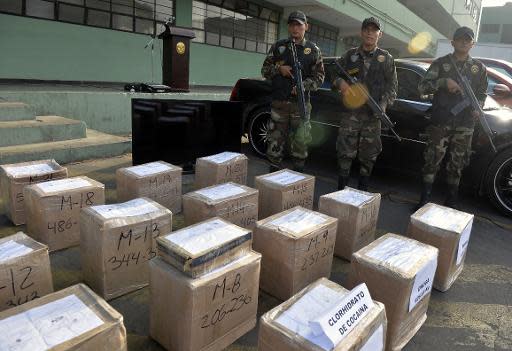 Soldados peruanos en la presentación a la prensa de drogas y químicos decomisados a una banda de traficantes locales y estadounidenses a la que se le capturaron 620 kilos de cocaína destinada al mercado norteamericana, en la división antinarcóticos de la policía, el 31 de marzo de 2014, en Lima. (AFP | Cris Borouncle)