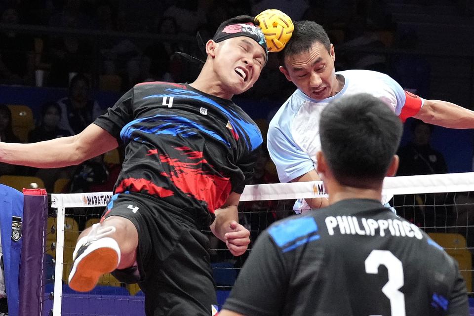 Philippines' Rheyjey Ortouste, left, and India's Niken Singh Khangembam, right, head the ball during men's sepaktakraw Group B preliminary match at Jinhua Sports Centre at the 19th Asian Games in Jinhua, China, Jinhua, Monday, Oct. 2, 2023. (AP Photo/Eugene Hoshiko)
