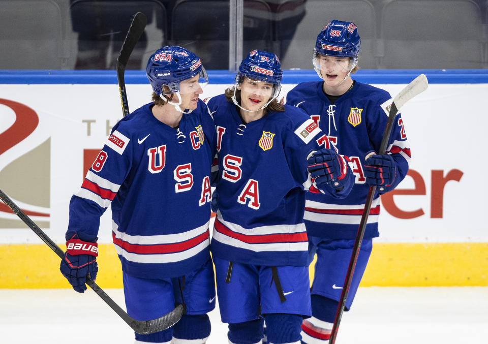 United States' Jake Sanderson (8), Tanner Dickinson (71) and Chaz Lucius (28) celebrate a goal against Finland during the first period of an exhibition game in Edmonton, Alberta, Thursday, Dec. 23, 2021, before the IIHF World Junior Hockey Championship tournament. (Jason Franson/The Canadian Press via AP)