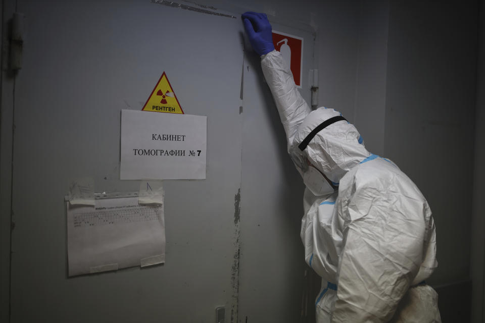 A medical staff member leans on a door while a patient with COVID-19 gets through a Magnetic resonance imaging system at an ICU of an hospital in Krasnodar, southern Russia, Thursday, Jan. 27, 2022. Russia has confirmed 11,404,617 cases of coronavirus and 328,770 deaths, according to the national coronavirus information center. Russia's total excess fatality count since the start of the coronavirus pandemic is at least 929,000. Under half the population is fully vaccinated. (AP Photo/Vitaliy Timkiv)