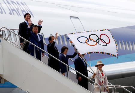 Tokyo governor Yuriko Koike (R) waves the Olympic flag as she walks out of a plane during a ceremony to mark the arrival of the Olympic flag at Haneda airport in Tokyo, Japan, August 24, 2016. REUTERS/Kim Kyung-Hoon