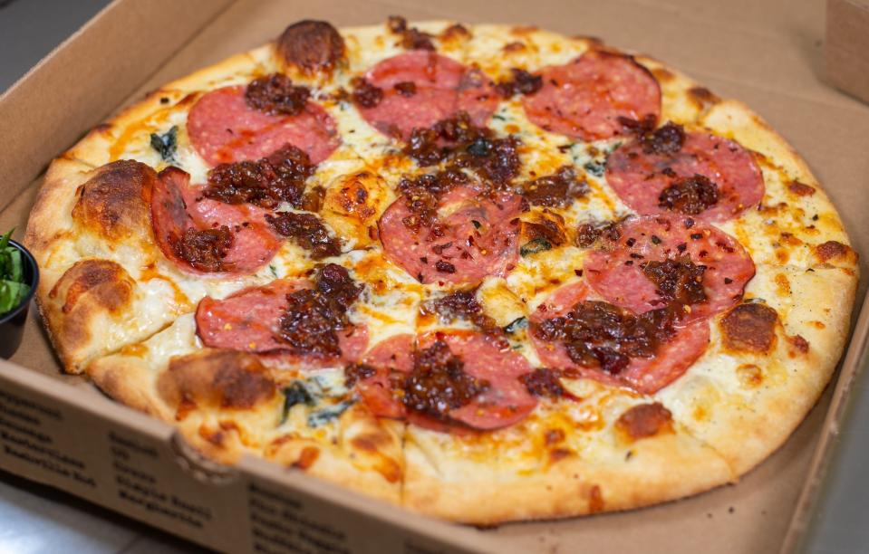 The Sweet Revenge salami, hot honey, and onion jam pizza from Zalat Pizza, displayed in a box