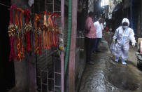 Rakhi', or sacred thread is displayed for sale as a health worker arrives to screen residents for COVID-19 symptoms at Dharavi, one of Asia's biggest slums, in Mumbai, India, Monday, Aug. 3, 2020. Marked the 'Raksha Bandhan' festival when sisters tie the thread on the wrists of brothers. (AP Photo/Rafiq Maqbool)