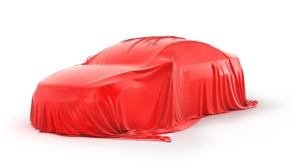 Image of a car with a red sheet on top of it.