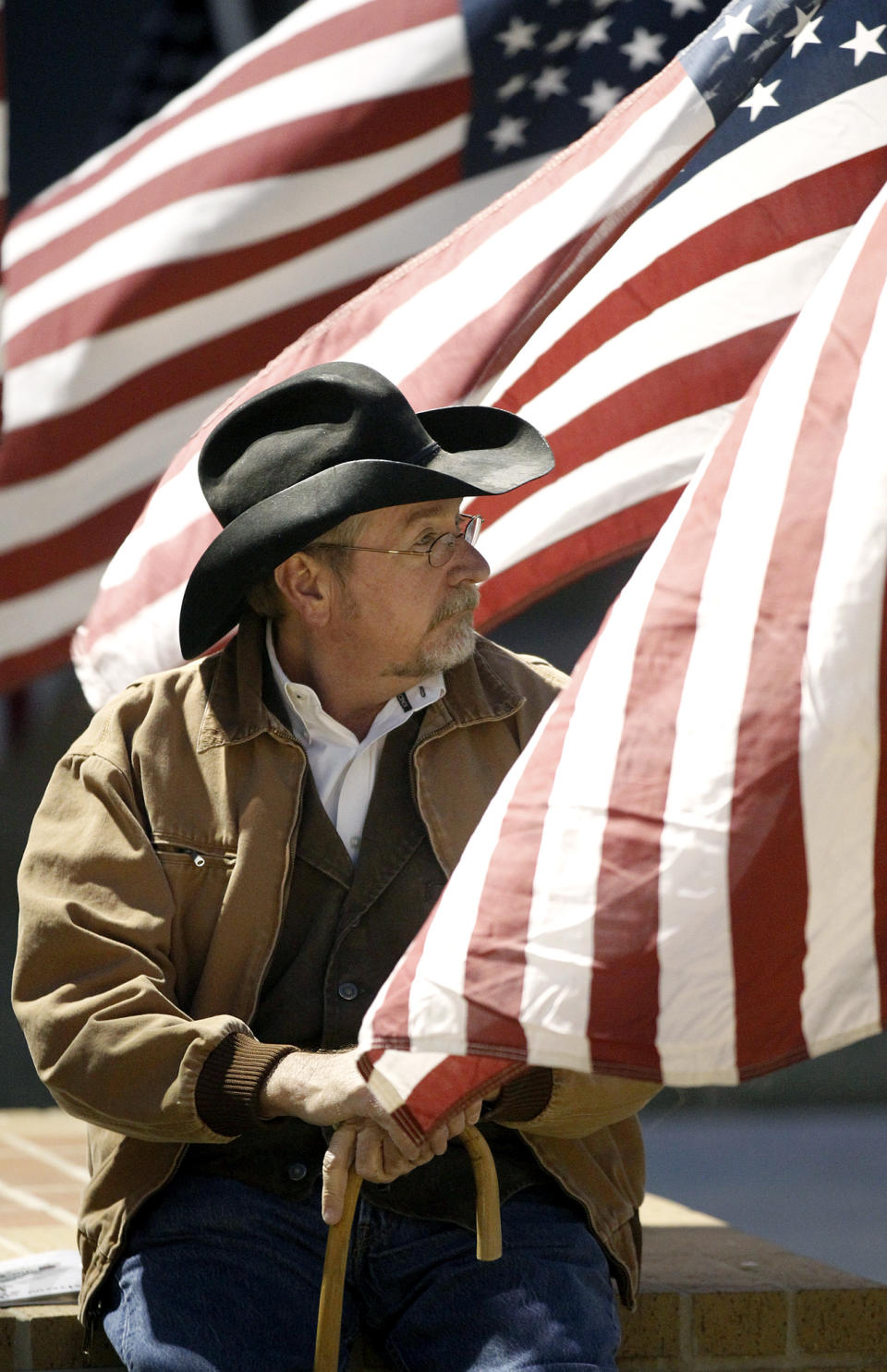 A candlelight vigil participant rests prior to the start of a memorial service held Saturday, Nov. 17, 2012 in Centennial Plaza in Midland, Texas in honor of four veterans who were killed when a freight train hit a parade float Thursday. (AP Photo/Midland Reporter-Telegram, James Durbin)