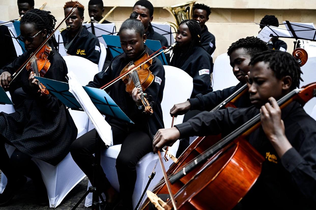 Members of the Ghetto Classics orchestra group plays music during the reopening ceremony of the DusitD2 hotel on July 31, 2019, in Nairobi