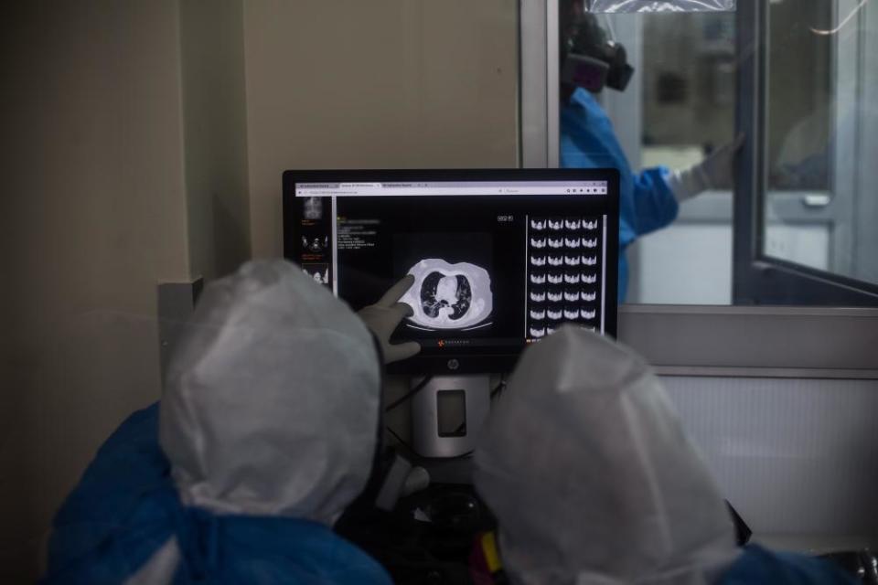 Medical personnel, assisting patients with COVID-19, look on a screen at Guillermo Almenara Hospital in Lima, Peru.