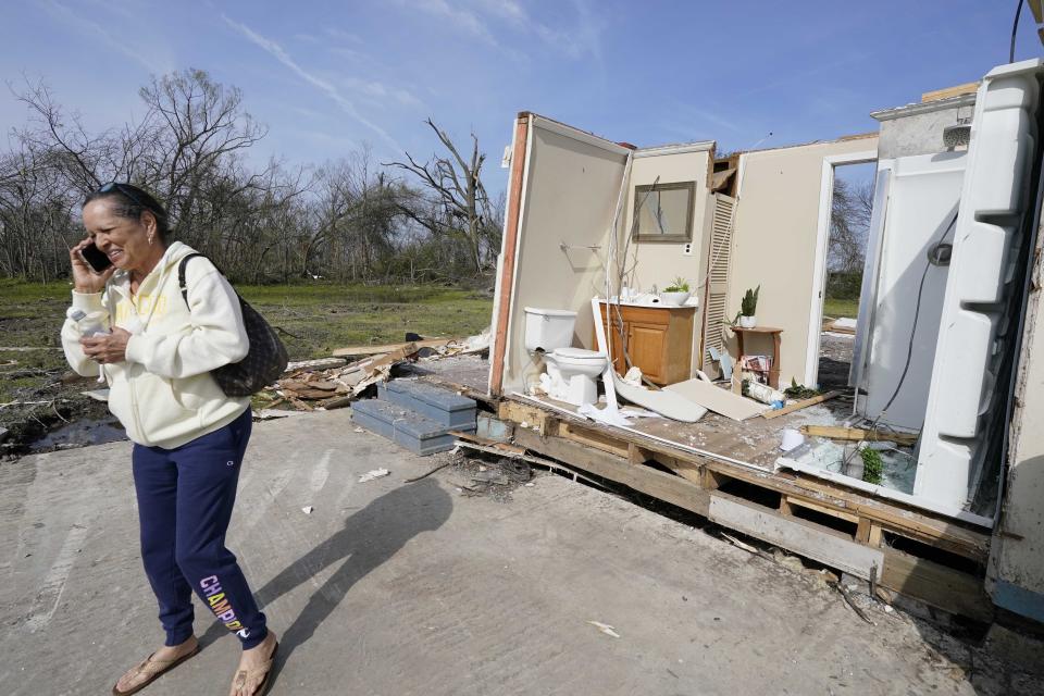 Patricia Johnson uses her cell phone as she walks away from her home that was destroyed by Friday night's killer tornado in Silver City, Miss., Tuesday, March 28, 2023. Johnson is married to a county supervisor, and like many of the small community's residents, lost much of their personal possessions and vehicles to the storm. (AP Photo/Rogelio V. Solis)