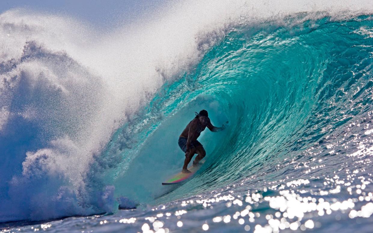 Mr Perry on his board, entirely enclosed in a tube of turquoise seawater