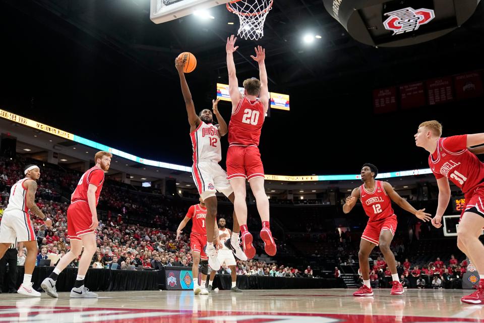 Mar 19, 2024; Columbus, OH, USA; Ohio State Buckeyes guard Evan Mahaffey (12) shoots around Cornell Big Red forward Sean Hansen (20) during the first half of the NIT basketball game at Value City Arena.