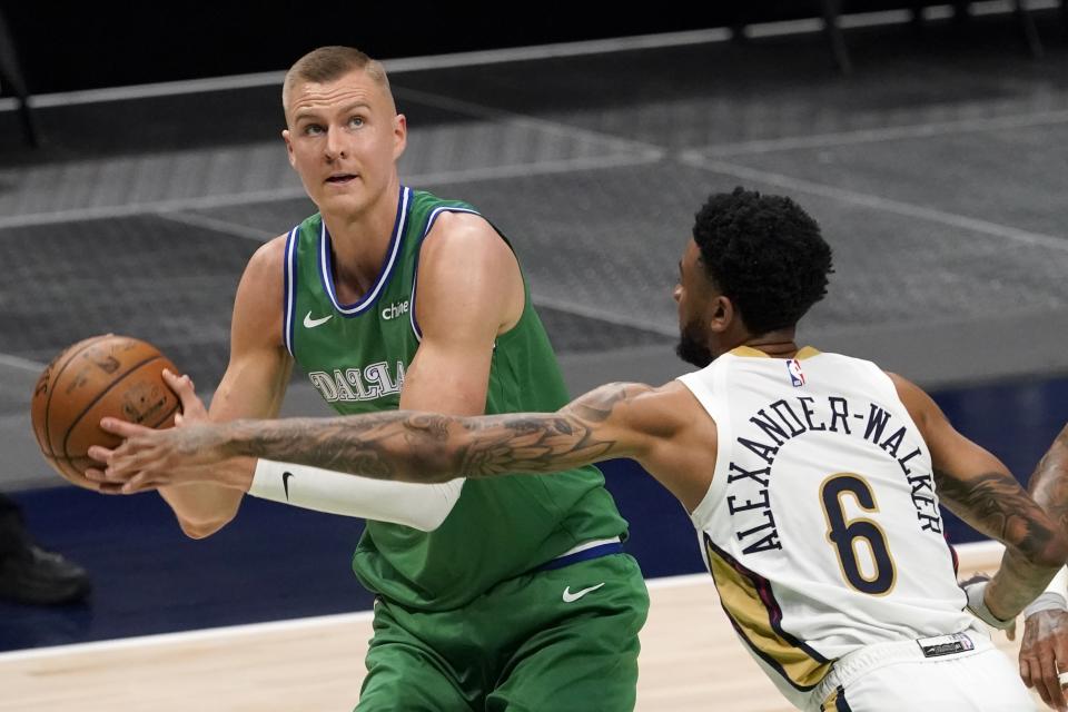 Dallas Mavericks center Kristaps Porzingis, left, works against New Orleans Pelicans guard Nickeil Alexander-Walker (6) for a shot opportunity during the first half of an NBA basketball game in Dallas, Wednesday, May 12, 2021. (AP Photo/Tony Gutierrez)