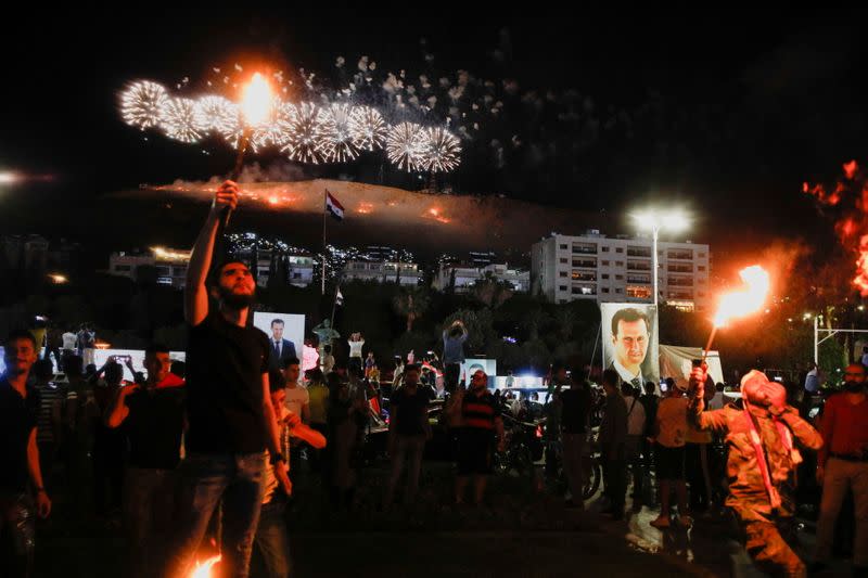 Supporters of of Syria's President Bashar al-Assad celebrate after the results of the presidential election announced that he won a fourth term in office, in Damascus