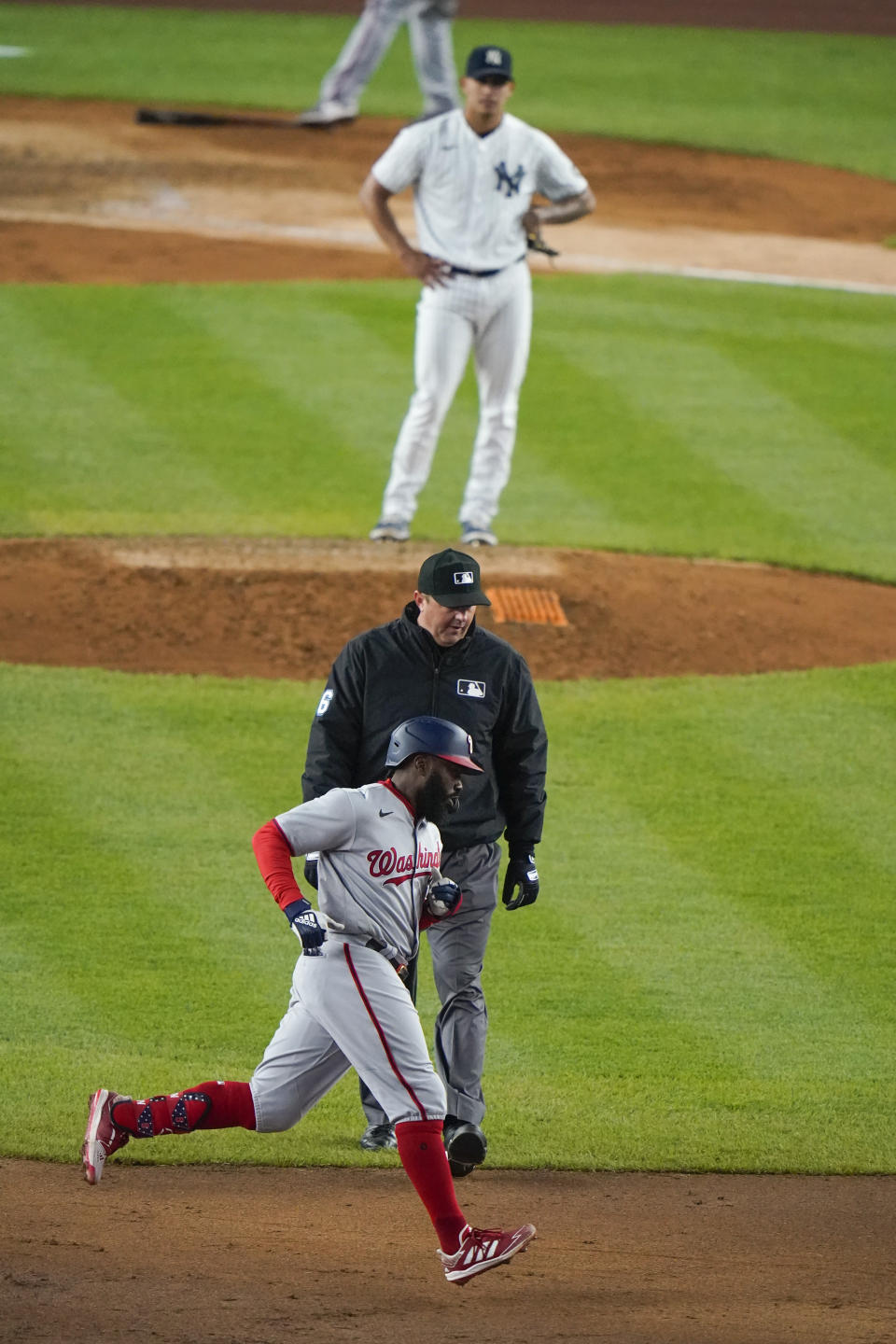 Washington Nationals' Josh Harrison runs the bases after hitting a three-run home run during the eighth inning of a baseball game as New York Yankees starting pitcher Jonathan Loaisiga watches, Friday, May 7, 2021, in New York. (AP Photo/Frank Franklin II)