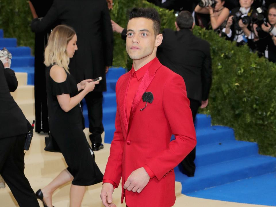 Rami Malek at the 2017 met gala wearing a bright red suit.