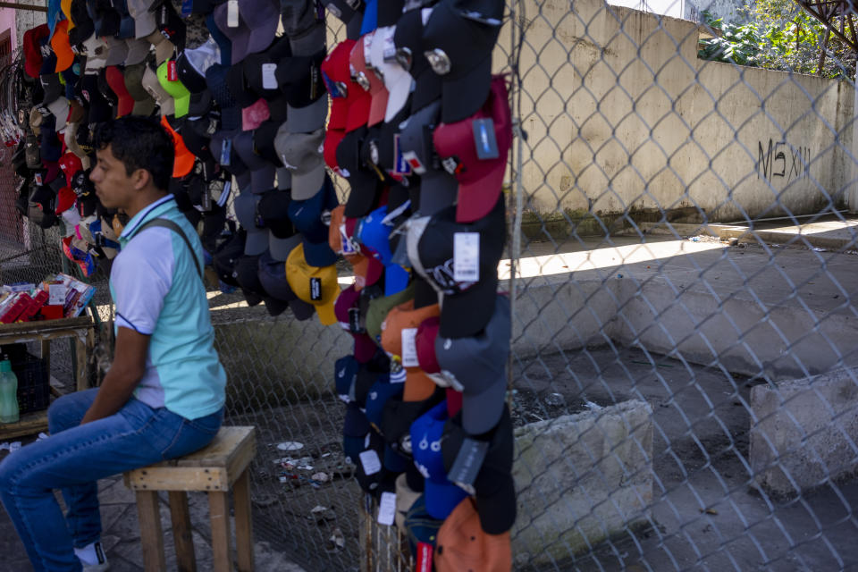 Un hombre vende gorras al lado de una barda que muestra un grafiti de pandillas de la Mara Salvatrucha, o pandilla MS-13, cerca de una estación de transporte público en Tapachula, México, el miércoles 18 de enero de 2023. Organizaciones de la delincuencia organizada, entre ellas las pandillas rivales Mara Salvatrucha y Barrio 18, llevan mucho tiempo presentes en la zona fronteriza entre México y Guatemala, pero las autoridades mexicanas dicen que su número ha aumentado durante el último año a medida que El Salvador ha tomado medidas enérgicas contra los pandilleros. (AP Foto/Moisés Castillo)