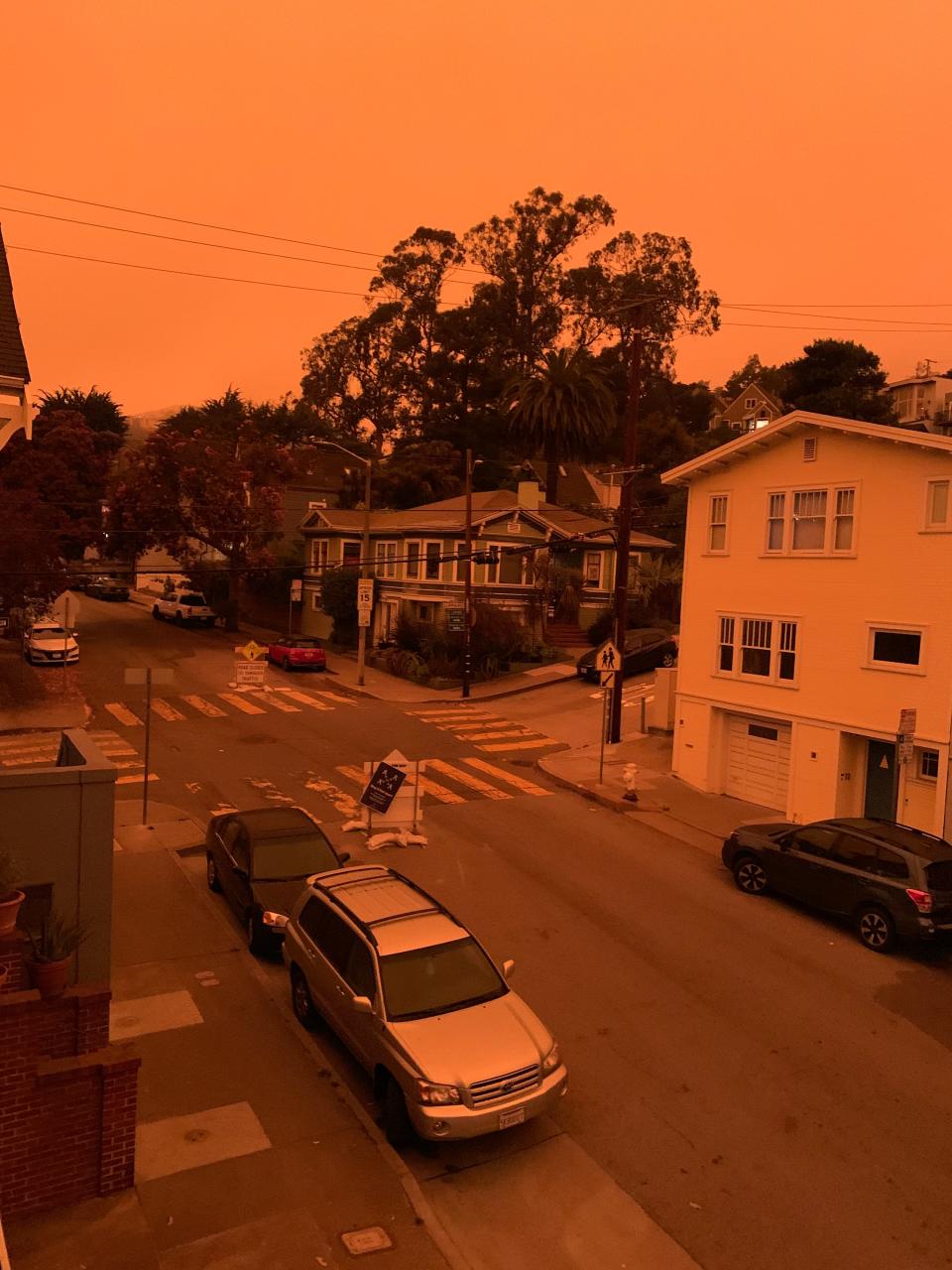 San Francisco's Glen Park neighborhood at 9:55 am Pacific Daylight Time on Wednesday, September 9, 2020. Smoke from numerous wildfires over a layer of marine fog turned the sky an eerie orange color. Cars were using headlines and some street lights were still on.