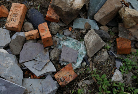 A destroyed part of a car windscreen is seen among the stones and bricks at the site where Mohammed Azam was killed in a mob lynching attack in Murki village in Bidar, India, July 19, 2018. REUTERS/Danish Siddiqui