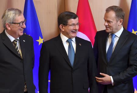 Turkish Prime Minister Ahmet Davutoglu is welcomed by European Commission President Jean-Claude Juncker (L) and European Council President Donald Tusk (R) during anEU-Turkey summit in Brussels, as the bloc is looking to Ankara to help it curb the influx of refugees and migrants flowing into Europe, March 7, 2016. REUTERS/Emmanuel Dunand/Pool