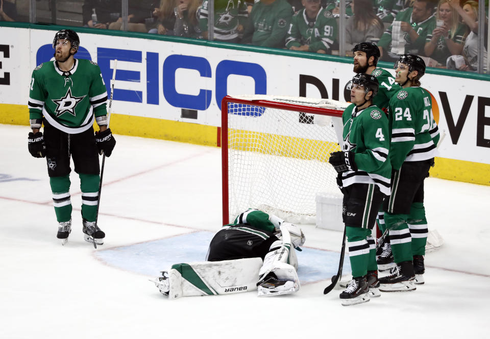 Members of the Dallas Stars look up at a replay after a shot from St. Louis Blues' Colton Parayko injured Stars goaltender Ben Bishop, laying on ice, leading to a goal by Blues' Jaden Schwartz during the third period in Game 6 of an NHL second-round hockey playoff series, Sunday, May 5, 2019, in Dallas. (AP Photo/Tony Gutierrez)