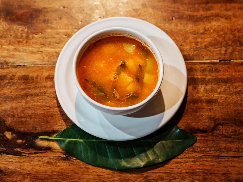 Squash soup with vanilla in a white cup on a saucer