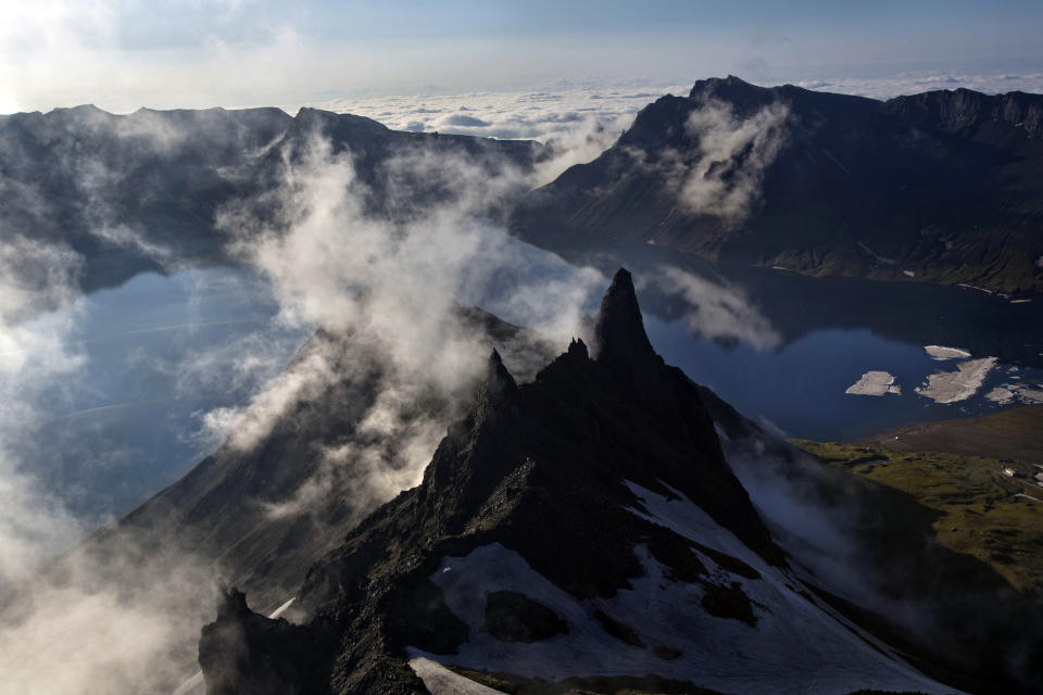 FILE - In this June 18, 2014, file photo, clouds float over the peak of Mount Paektu in North Korea. There is no more sacred a place in North Korea than Mount Paektu. The still active volcano, site of one the most violent eruptions in history, is considered to be the spiritual epicenter of the North Korean revolution. (AP Photo/David Guttenfelder, File)