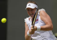 Latvia's Jelena Ostapenko returns to Romania's Irina-Camelia Begu during their women's third round singles match on day five of the Wimbledon tennis championships in London, Friday, July 1, 2022. (AP Photo/Kirsty Wigglesworth)