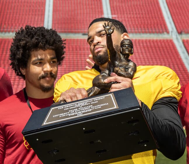 Los Angeles, CA - April 15: 2022 Former USC running back Travis Dye left, watches Heisman winner Caleb Williams.