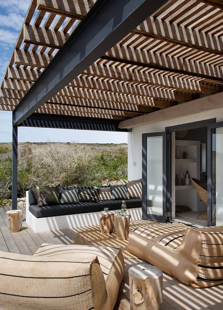 <p>A l’ombre d’une pergola en iroko et acier, la terrasse de cette ancienne maison de pêcheur accueille banquettes maçonnées et matelas confectionnés par des artisans locaux. Coussins en lin imprimé et brodé ( <a href="https://www.evolutionproduct.co.za/" rel="nofollow noopener" target="_blank" data-ylk="slk:Evolution Product;elm:context_link;itc:0;sec:content-canvas" class="link ">Evolution Product</a>) et lin uni ( <a href="https://www.madura.fr/fr_fr/" rel="nofollow noopener" target="_blank" data-ylk="slk:Madura;elm:context_link;itc:0;sec:content-canvas" class="link ">Madura</a>). Poufs version chaise longue en fibres outdoor tressées ( <a href="https://www.weylandts.co.za/" rel="nofollow noopener" target="_blank" data-ylk="slk:Weylandts;elm:context_link;itc:0;sec:content-canvas" class="link ">Weylandts</a>), tabourets en bois ( <a href="http://lagrangeinteriors.co.za/" rel="nofollow noopener" target="_blank" data-ylk="slk:La Grange Interiors;elm:context_link;itc:0;sec:content-canvas" class="link ">La Grange Interiors</a>) et tapis en jute (Herringbone).</p><br>