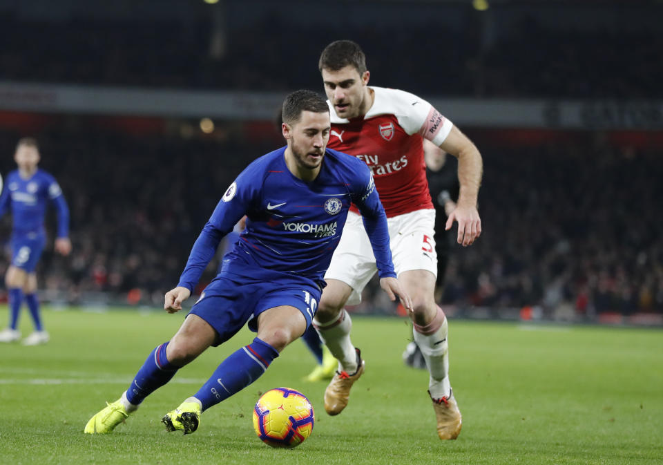 Chelsea's Eden Hazard, left vies for the ball with Arsenal's Sokratis Papastathopoulos during the English Premier League soccer match between Arsenal and Chelsea at the Emirates stadium in London, Saturday, Jan. 19, 2019. (AP Photo/Frank Augstein)