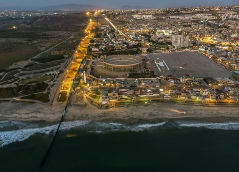 An aerial view of the United States (L) - Mexico (R) border fence extending into the Pacific ocean at Playas de Tijuana, Mexico