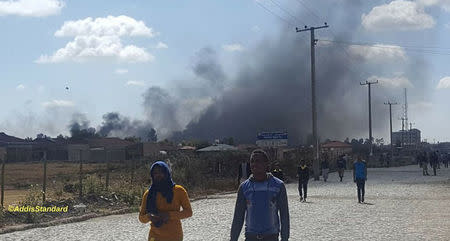 Plumes of smoke are seen behind buildings in Addis Ababa, Oromia, Ethiopia February 13, 2018 in this still image obtained from social media video, Courtesy of TWITTER/@ADDISSTANDARD/via REUTERS