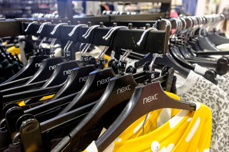 FILE PHOTO: Garments on coat hangers are pictured at a Next store in London