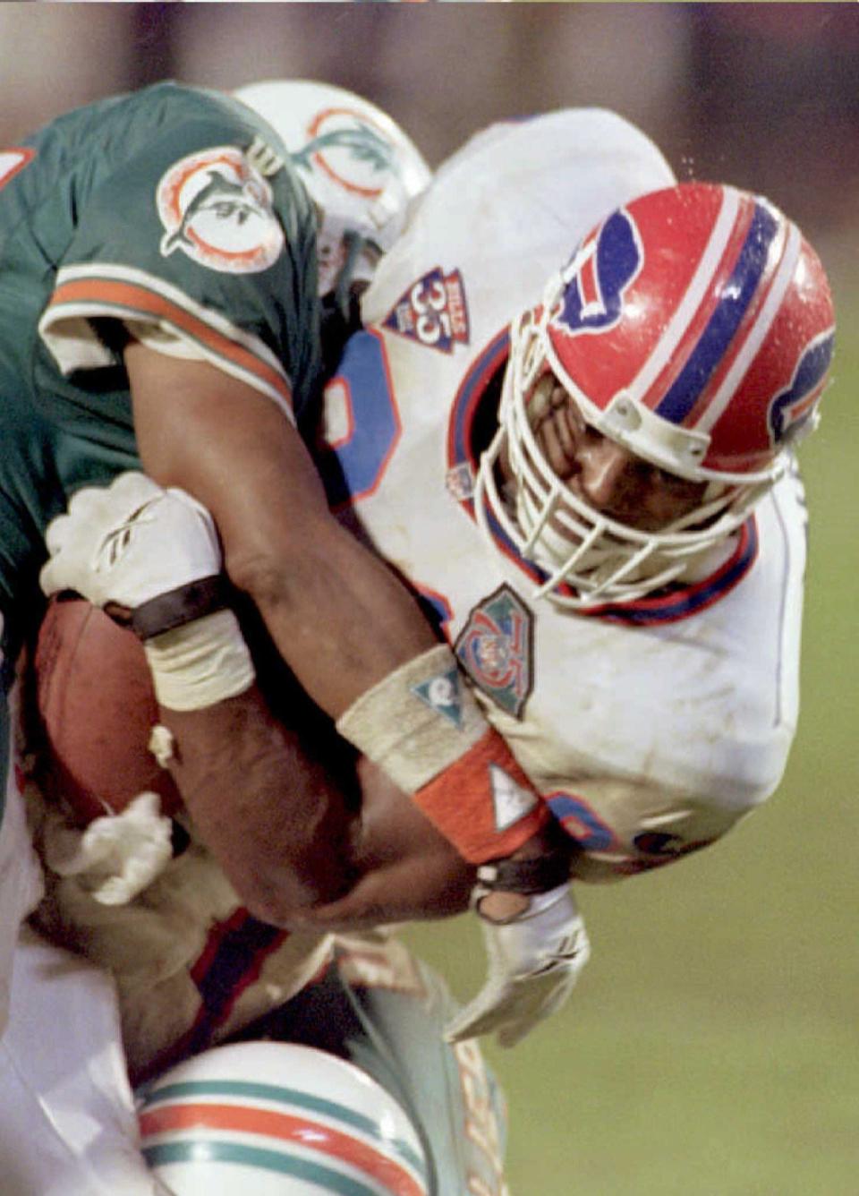 Buffalo Bills tight end Lonnie Johnson goes for first down yardage while Miami Dolphins Michael Stewart makes the tackle during fourth quarter action in Miami on Dec. 4, 1994.
