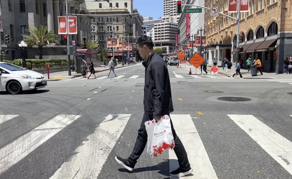 Andy Fang, DoorDash’s co-founder and chief technology officer, picks up and delivers food orders to customers in downtown San Francisco on Saturday, June 15, 2023. Fang is one of a growing number of executives who work shifts on the front lines of the companies they run. All DoorDash salaried employees are required to make deliveries or work directly with customers or merchants several times a year. (AP Photo/Terry Chea)