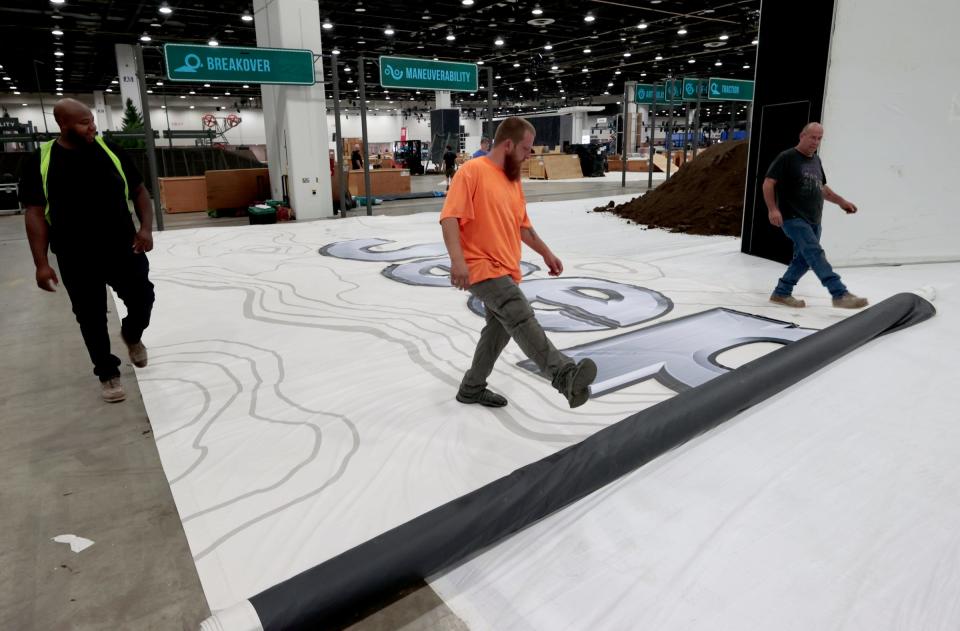 (L to R) Mareo Jenkins, 45 of Shelby Township and with Local 687, Matthew Howell, 34 of Waterford with Local 687 and Chris Belevender, 57 of Royal Oak with Local 202 roll out large Jeep signage on the floor during set up inside Huntington Place in downtown Detroit on Wednesday, September 6, 2023, for the North American International Auto Show that starts next week.
Thirty-five brands from Buick to Ford, Toyota to Kia and others will have cars on display during the popular auto show.