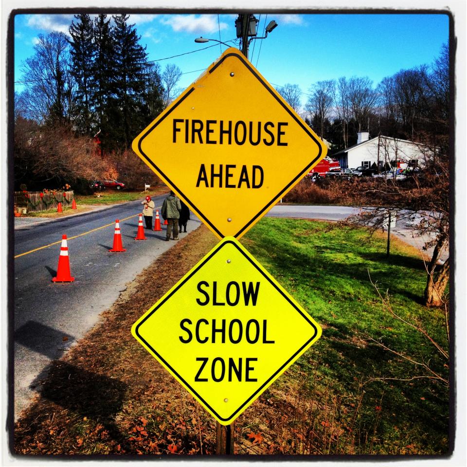 Road signs near the entrance to Sandy Hook Elementary School in Newtown, Conn., read: Firehouse ahead, and Slow school zone.