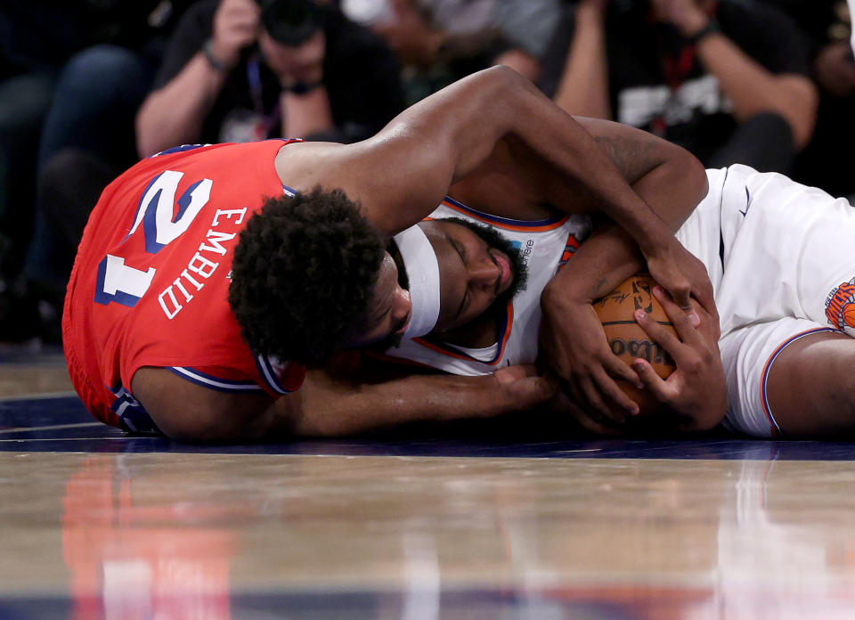 NEW YORK, NEW YORK - APRIL 20: Joel Embiid #21 of the Philadelphia 76ers and Mitchell Robinson #23 of the New York Knicks fight for the loose ball during the second half in game one of the Eastern Conference First Round Playoffs at Madison Square Garden on April 20, 2024 in New York City. The New York Knicks defeated the Philadelphia 76ers 111-104. NOTE TO USER: User expressly acknowledges and agrees that, by downloading and or using this photograph, User is consenting to the terms and conditions of the Getty Images License Agreement. (Photo by Elsa/Getty Images)