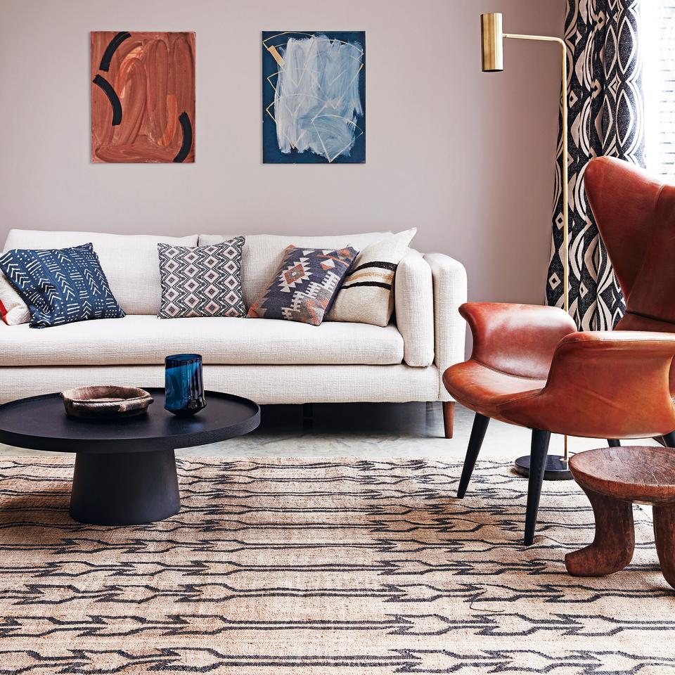 Living room with rug and cream sofa.